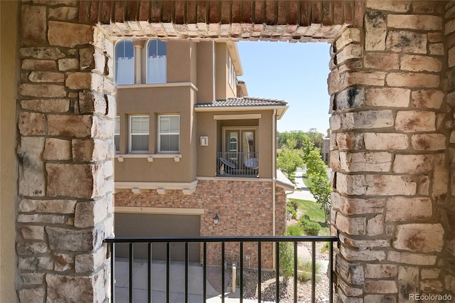 3437 Rosato Dr Unit C, Highlands Ranch, CO 80126 - view of exterior entry featuring a tiled roof, a balcony, and stone siding