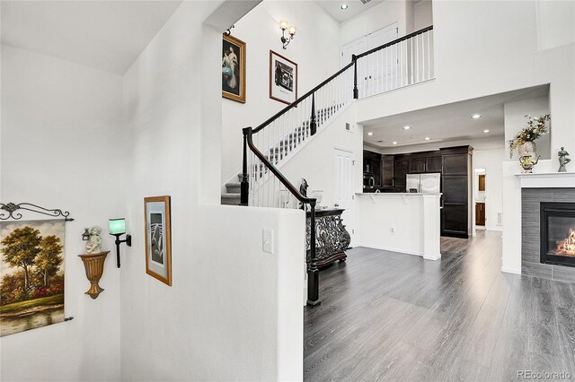 3437 Rosato Dr Unit C, Highlands Ranch, CO 80126 - stairs with a high ceiling, wood finished floors, a tile fireplace, and recessed lighting