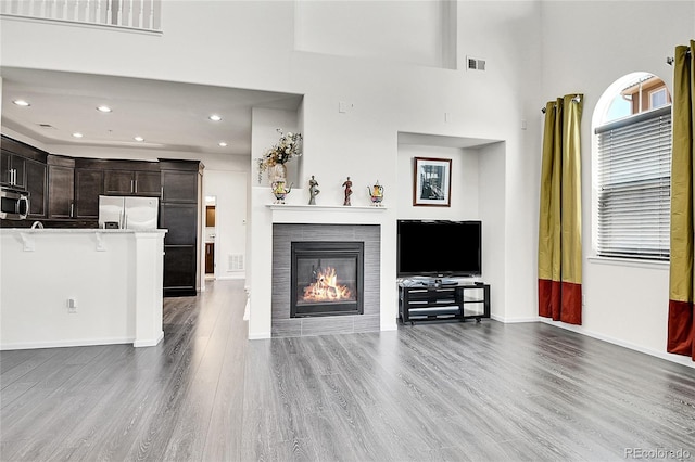 3437 Rosato Dr Unit C, Highlands Ranch, CO 80126 - living area with wood finished floors, a tile fireplace, recessed lighting, baseboards, and a high ceiling