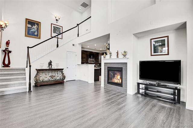 3437 Rosato Dr Unit C, Highlands Ranch, CO 80126 - living room featuring wood finished floors, stairway, a tile fireplace, baseboards, and a high ceiling