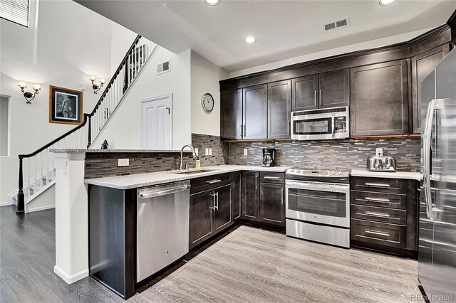 3437 Rosato Dr Unit C, Highlands Ranch, CO 80126 - kitchen featuring stainless steel appliances, a sink, a peninsula, dark brown cabinets, and recessed lighting