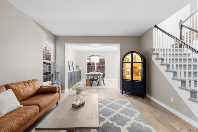 living area with a healthy amount of sunlight, stairs, and light wood-style floors