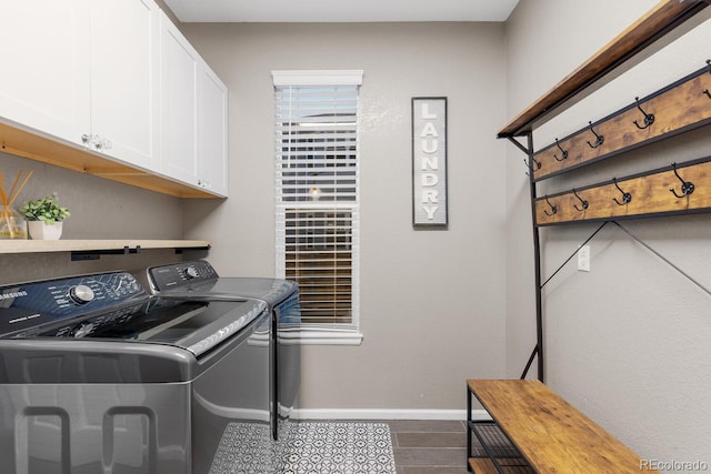 clothes washing area featuring washing machine and dryer, cabinet space, baseboards, and dark wood-style flooring