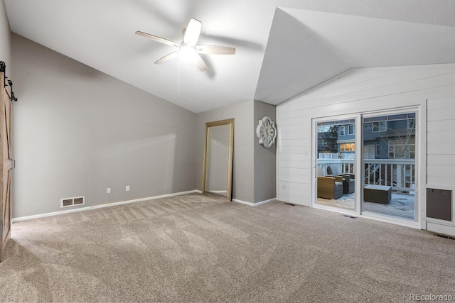 unfurnished bedroom with visible vents, carpet flooring, and vaulted ceiling