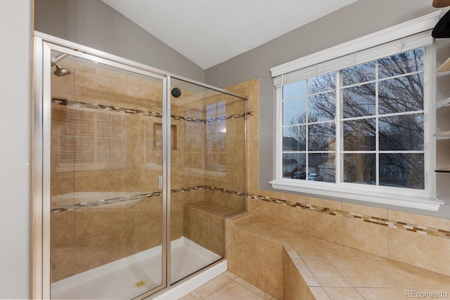 bathroom with lofted ceiling, a stall shower, and tile patterned flooring