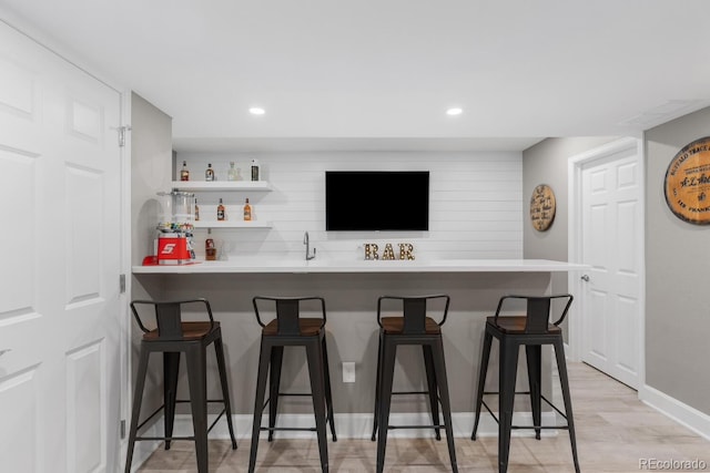 bar featuring wet bar, light wood-style flooring, recessed lighting, and baseboards