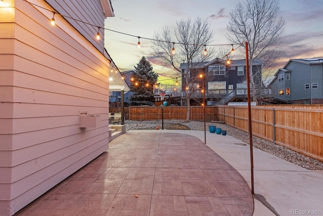 patio terrace at dusk with a fenced backyard