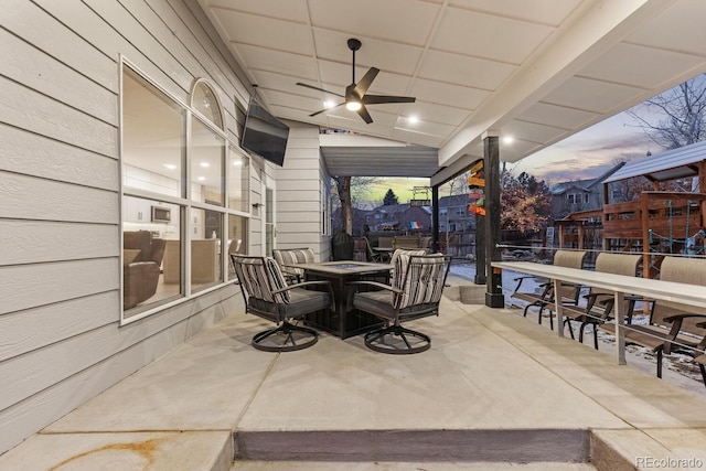 view of patio with outdoor dining area and a ceiling fan