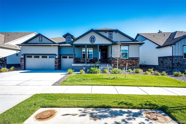 craftsman-style home with covered porch, a garage, and a front lawn