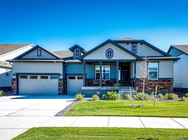 craftsman-style home featuring a front yard, covered porch, and a garage