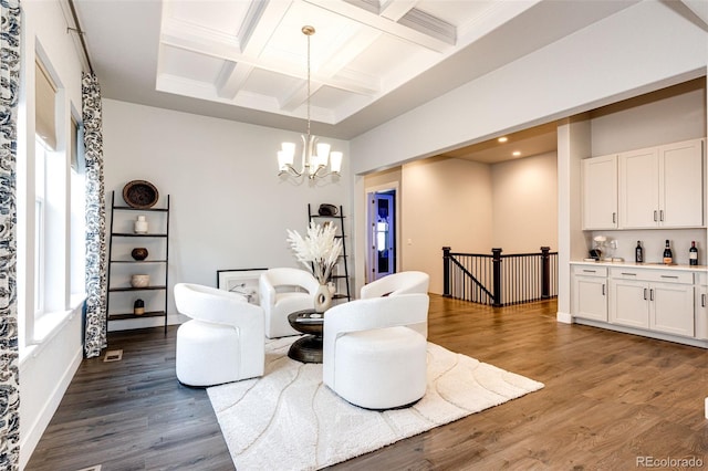 living room with beam ceiling, coffered ceiling, a notable chandelier, and wood-type flooring