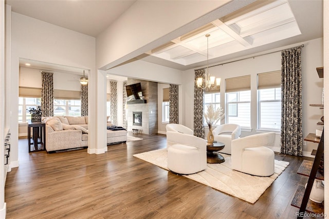 living room featuring beamed ceiling, dark wood-type flooring, coffered ceiling, and plenty of natural light