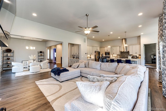 living room featuring hardwood / wood-style flooring and ceiling fan with notable chandelier