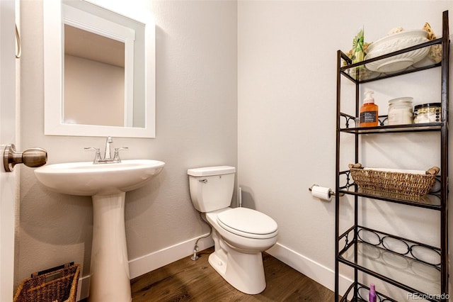 bathroom with toilet and hardwood / wood-style floors