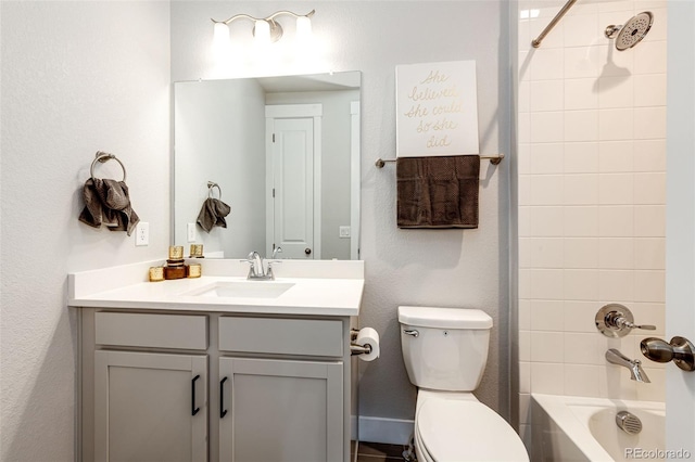 full bathroom with tiled shower / bath, vanity, and toilet