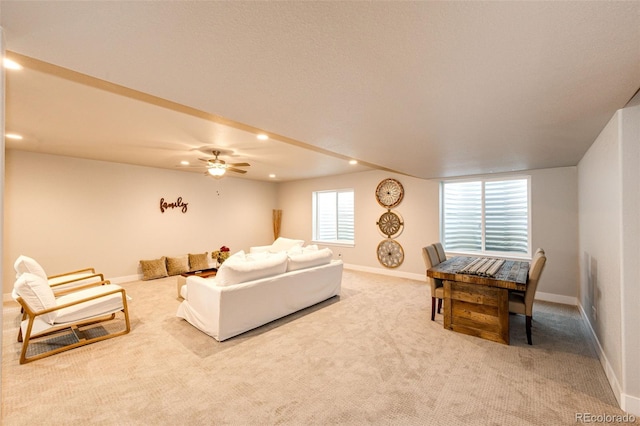 carpeted living room with ceiling fan