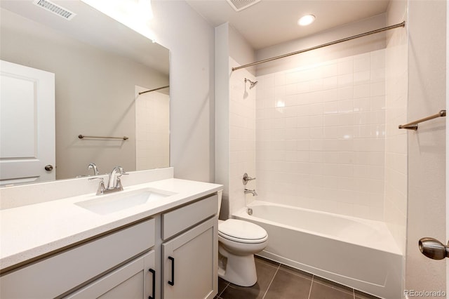 full bathroom with toilet, tiled shower / bath, vanity, and tile patterned floors