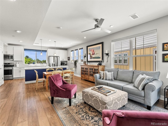 6162 W 28th Ct, Edgewater, CO 80214 - living room with plenty of natural light, light wood-style floors, a ceiling fan, and recessed lighting