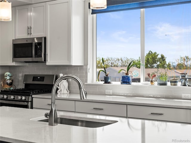 6162 W 28th Ct, Edgewater, CO 80214 - kitchen featuring stainless steel appliances, white cabinets, decorative backsplash, and a sink