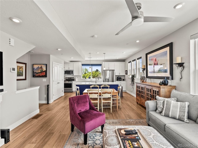 6162 W 28th Ct, Edgewater, CO 80214 - living area featuring light wood-style flooring, plenty of natural light, a ceiling fan, recessed lighting, and baseboards