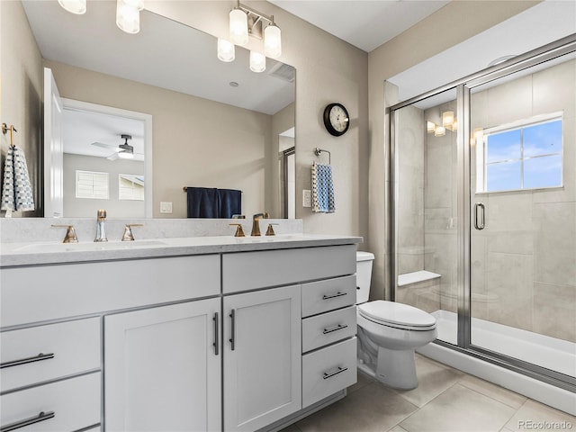 6162 W 28th Ct, Edgewater, CO 80214 - bathroom with a stall shower, toilet, tile patterned floors, double vanity, and ceiling fan