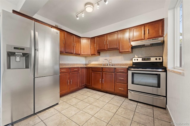 kitchen featuring light stone counters, stainless steel appliances, light tile patterned flooring, and sink