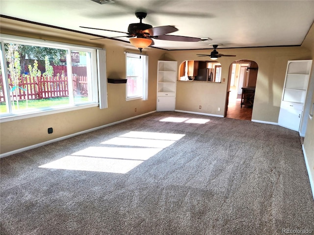 interior space with dark carpet and ceiling fan