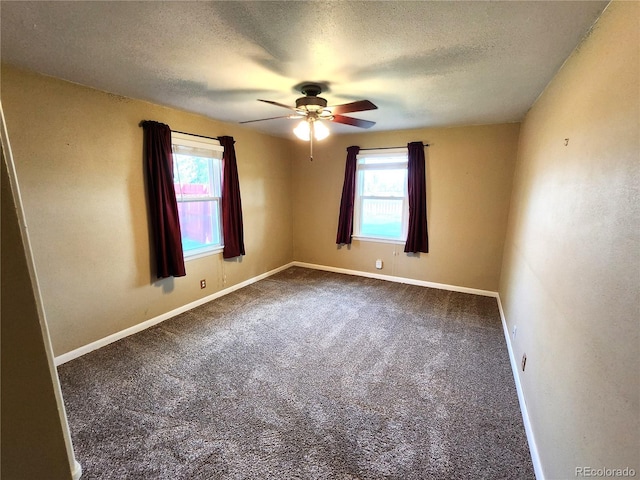 carpeted spare room with a wealth of natural light, ceiling fan, and a textured ceiling