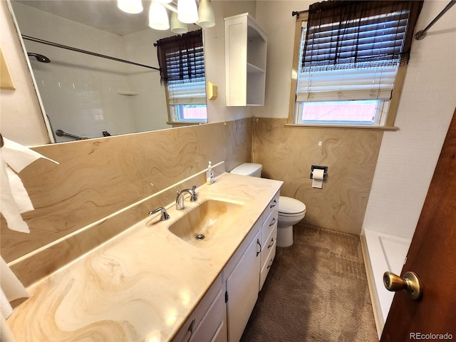 bathroom featuring vanity, toilet, and a shower