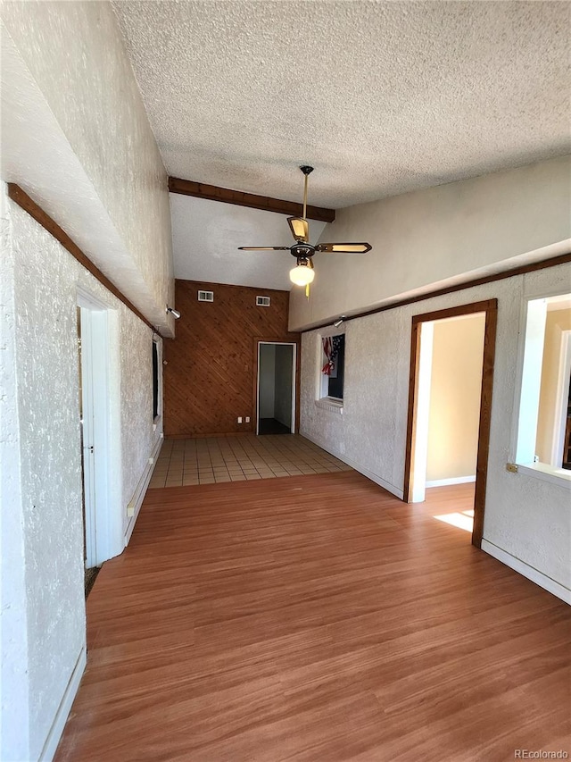 spare room with ceiling fan, light hardwood / wood-style floors, and a textured ceiling