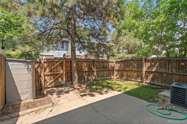 view of yard with central AC unit and a patio