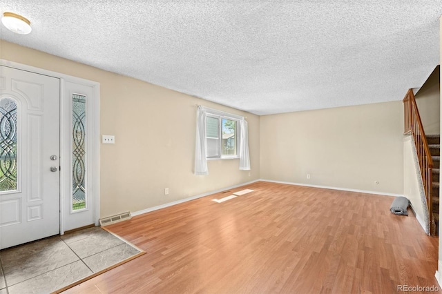 entryway featuring light hardwood / wood-style flooring and a textured ceiling