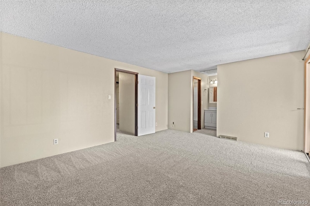 carpeted spare room featuring a textured ceiling