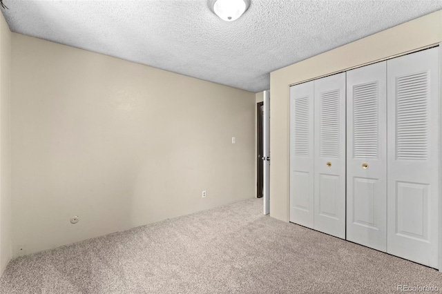 unfurnished bedroom with carpet flooring, a closet, and a textured ceiling