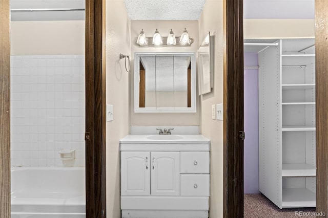 bathroom with vanity, tub / shower combination, and a textured ceiling