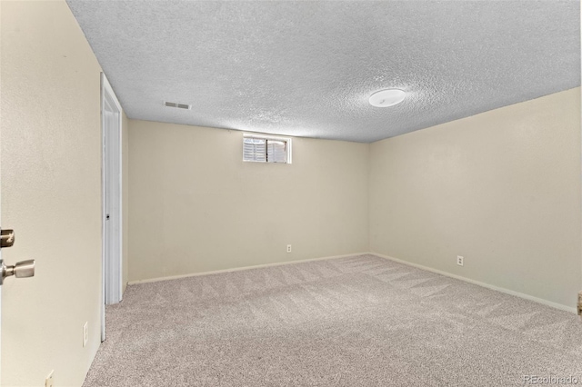 basement with light colored carpet and a textured ceiling