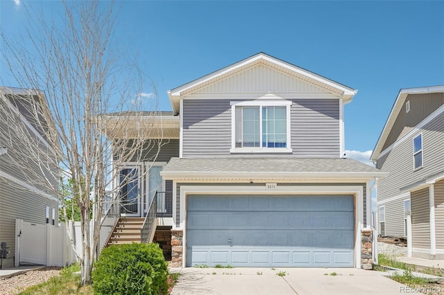 5571 Killarney St, Denver, CO 80249 - traditional home featuring a garage, stairs, driveway, roof with shingles, and fence