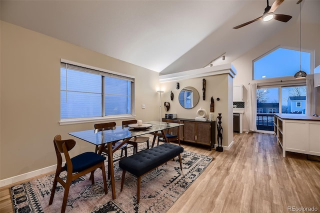 dining room featuring ceiling fan, light wood-type flooring, and high vaulted ceiling