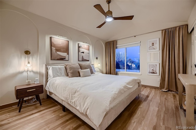 bedroom with ceiling fan, vaulted ceiling, and wood-type flooring