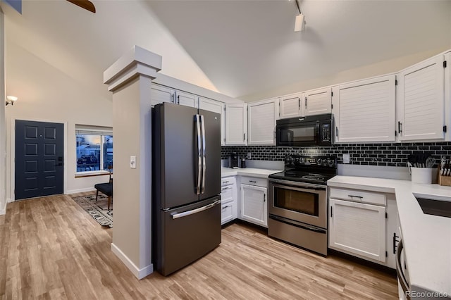 kitchen with light hardwood / wood-style floors, decorative backsplash, high vaulted ceiling, white cabinets, and appliances with stainless steel finishes