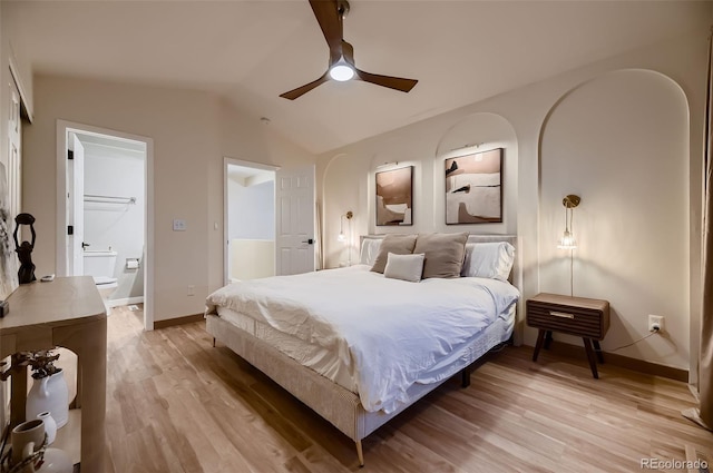 bedroom with connected bathroom, vaulted ceiling, a closet, light wood-type flooring, and ceiling fan