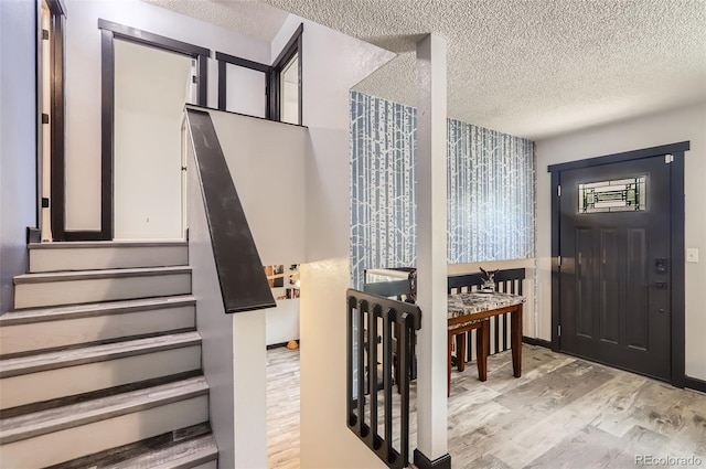 229 Ranae Dr, Loveland, CO 80537 - entrance foyer featuring wood finished floors, a textured ceiling, and stairway