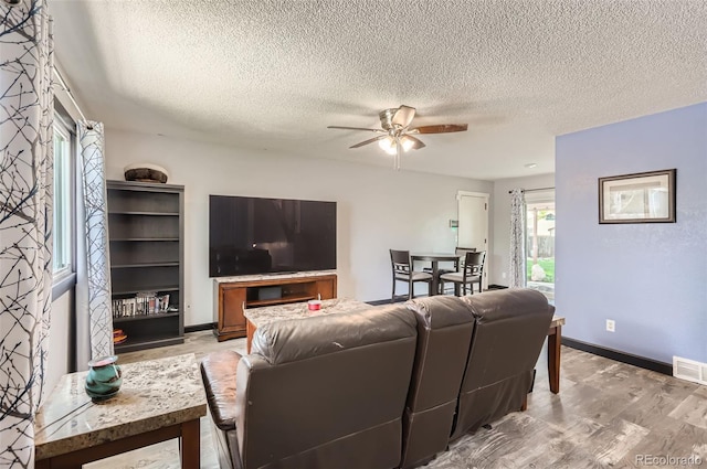 229 Ranae Dr, Loveland, CO 80537 - living room with a textured ceiling, light wood-style floors, a ceiling fan, and baseboards