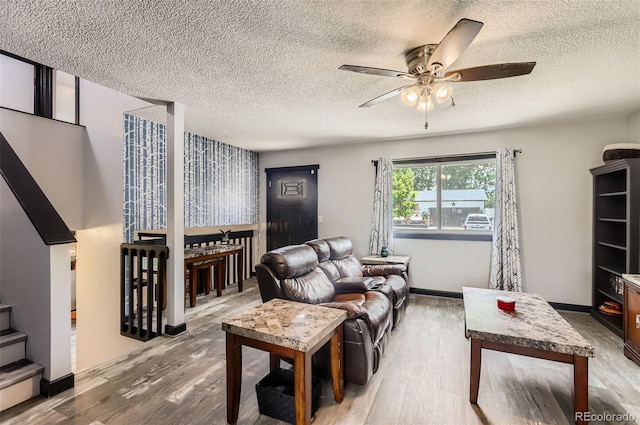 229 Ranae Dr, Loveland, CO 80537 - living room featuring wood finished floors, a ceiling fan, a textured ceiling, and stairway
