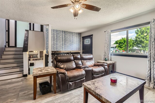 229 Ranae Dr, Loveland, CO 80537 - living room with a textured ceiling, a ceiling fan, light wood finished floors, and stairs