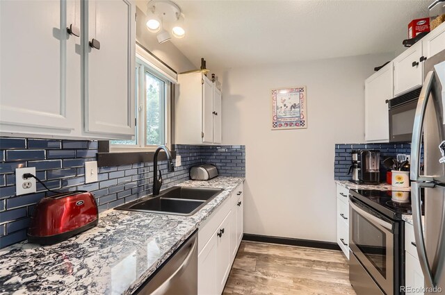 229 Ranae Dr, Loveland, CO 80537 - kitchen with stainless steel appliances, a sink, white cabinets, and tasteful backsplash