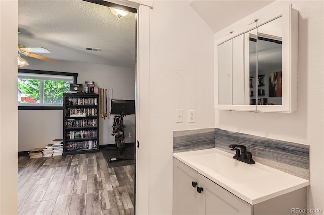 229 Ranae Dr, Loveland, CO 80537 - bathroom featuring wood finished floors, ceiling fan, vanity, and a textured ceiling