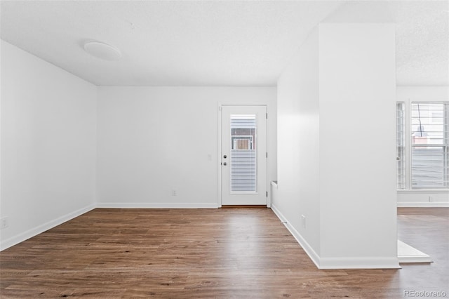 unfurnished room with hardwood / wood-style floors and a textured ceiling