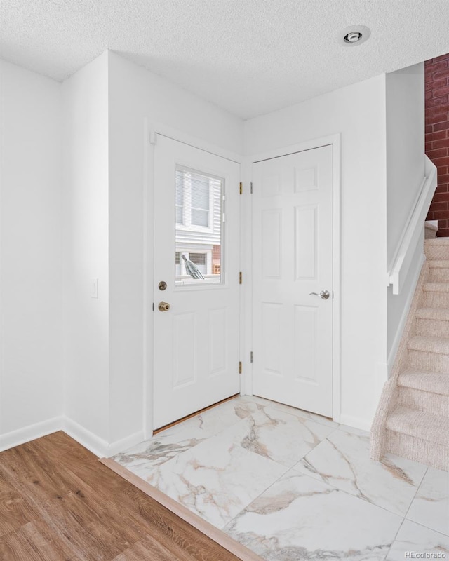 foyer entrance with a textured ceiling