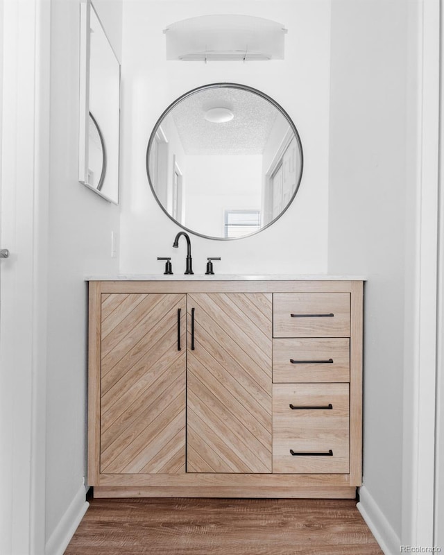 bathroom with vanity, hardwood / wood-style floors, and a textured ceiling